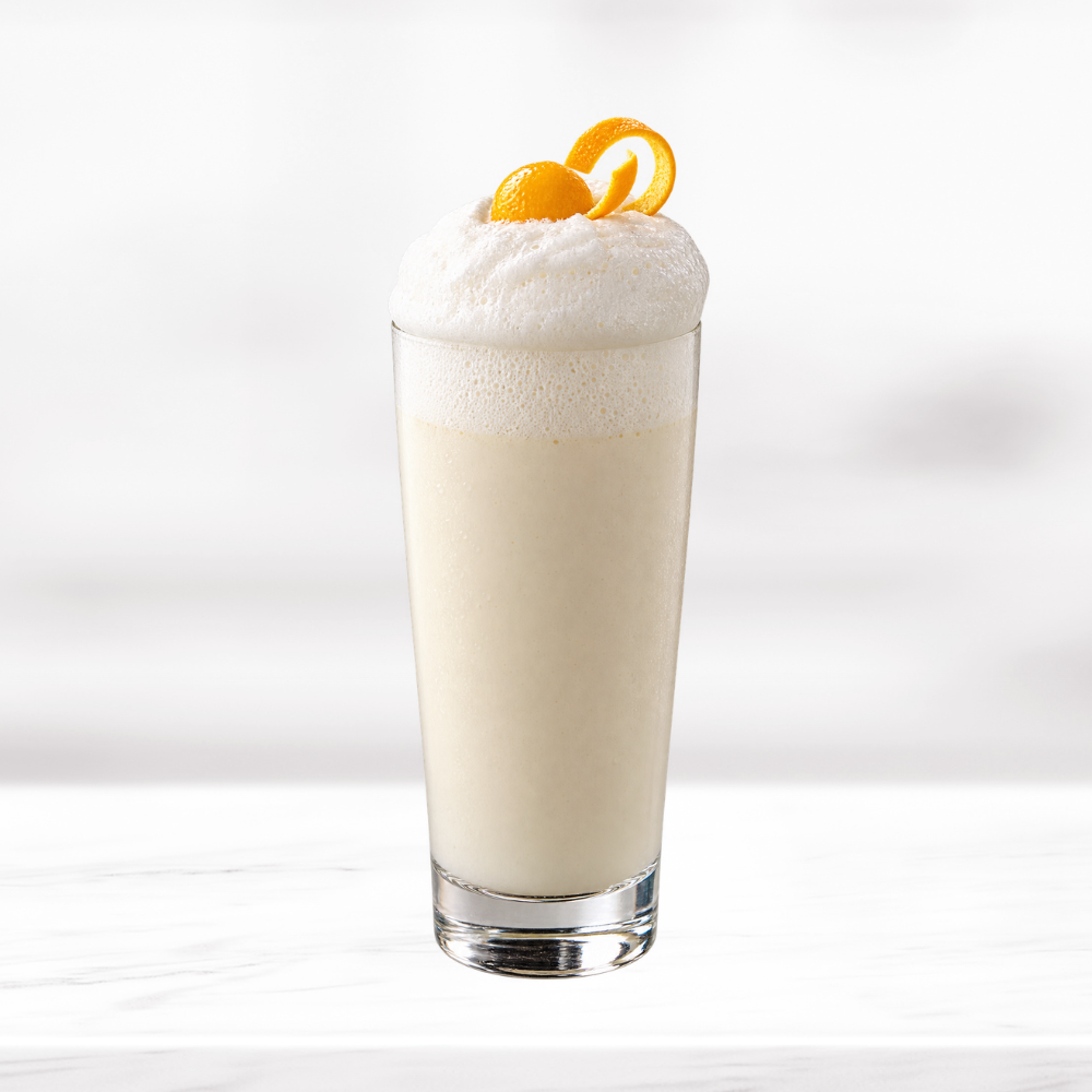 Creamy Banana Ramos cocktail with a thick foamy top and orange peel garnish