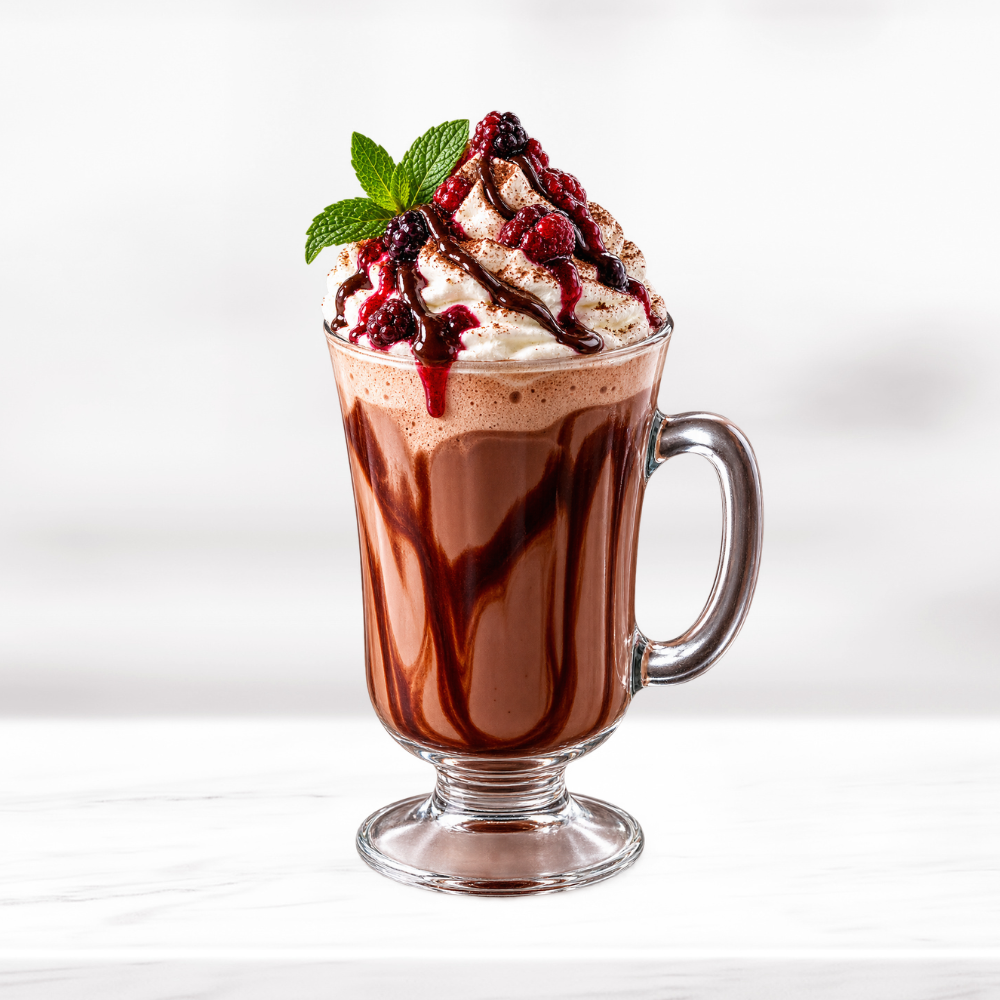 Black Forest hot chocolate topped with whipped cream, berries, chocolate drizzle and mint