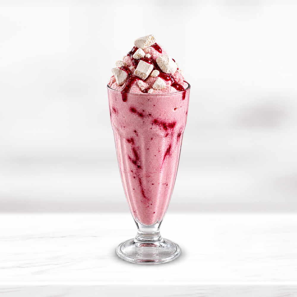 Pink Eton Mess frappe topped with meringue pieces and berry sauce